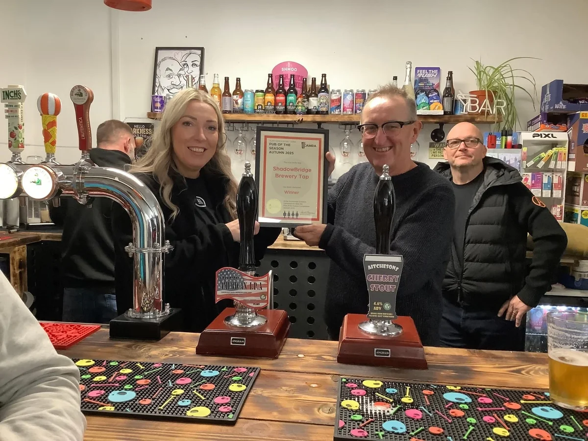 Heather receiving the Pub of the Season Autumn 2025 certificate from Scunthorpe CAMRA behind the bar